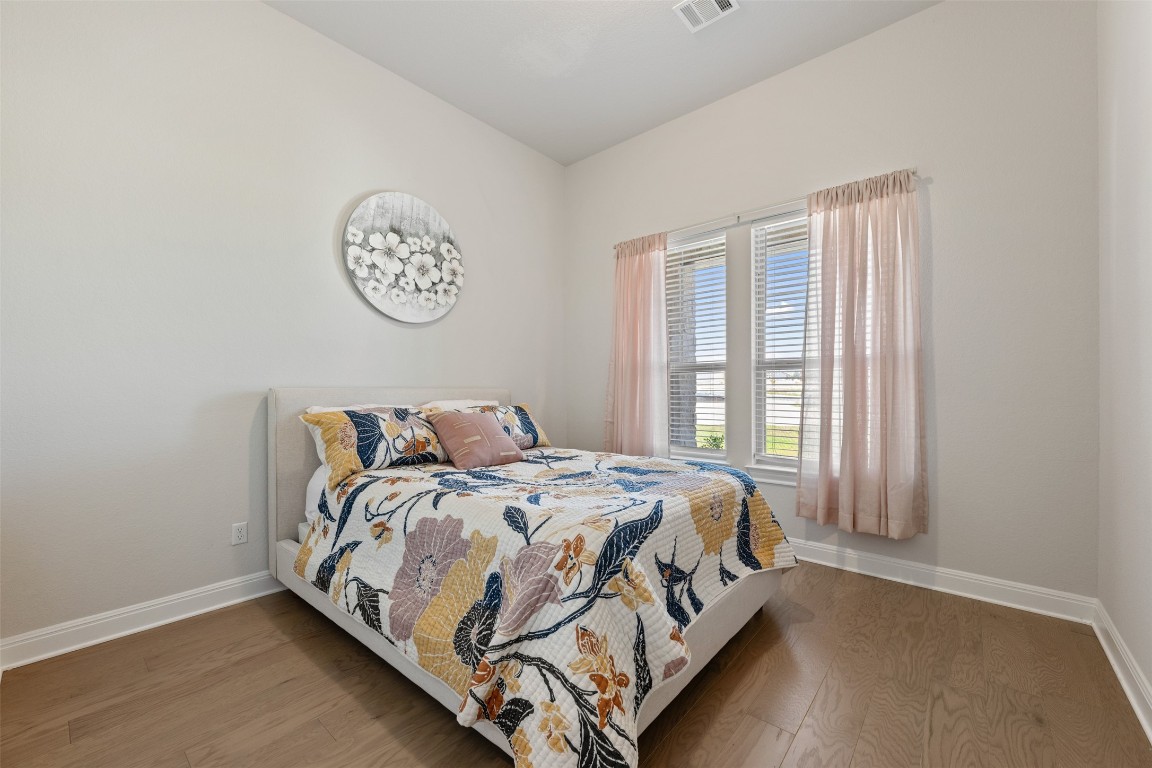 686 Treadwell Lane Kyle, TX 78640 - Photo 29 of 40 a bed sitting in a bedroom next to a window
