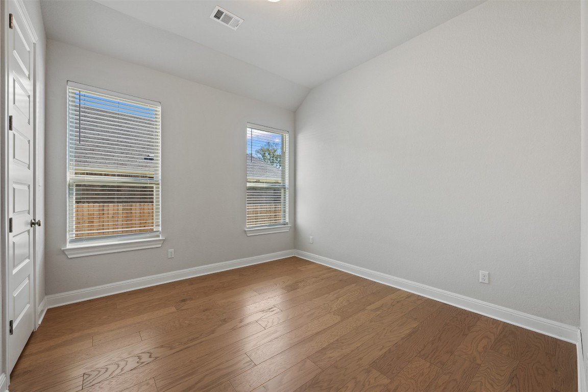 686 Treadwell Lane Kyle, TX 78640 - Photo 31 of 40 an empty room with wooden floor and windows