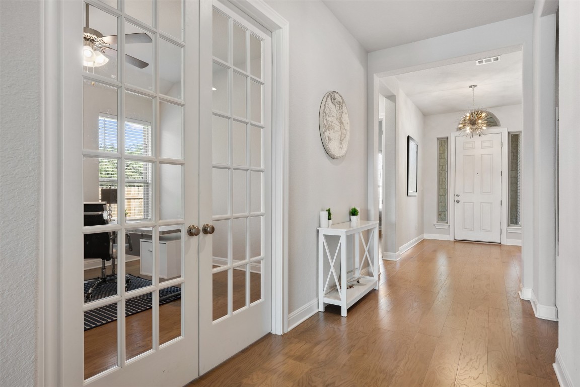 686 Treadwell Lane Kyle, TX 78640 - Photo 5 of 40 a view of a room with wooden floor and windows