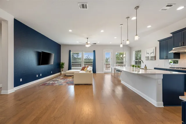 a large living room with stainless steel appliances wooden floor kitchen view and living room view