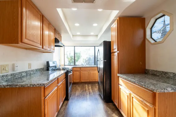 a kitchen with stainless steel appliances granite countertop a stove a sink and a refrigerator