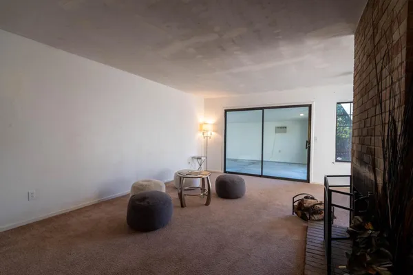 a view of an empty room and chandelier fan
