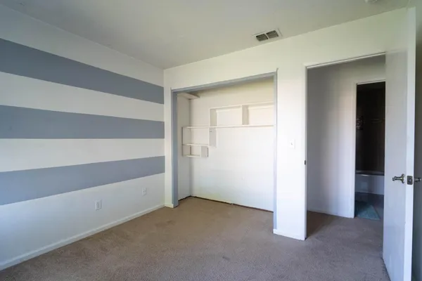 an empty room with windows and closet