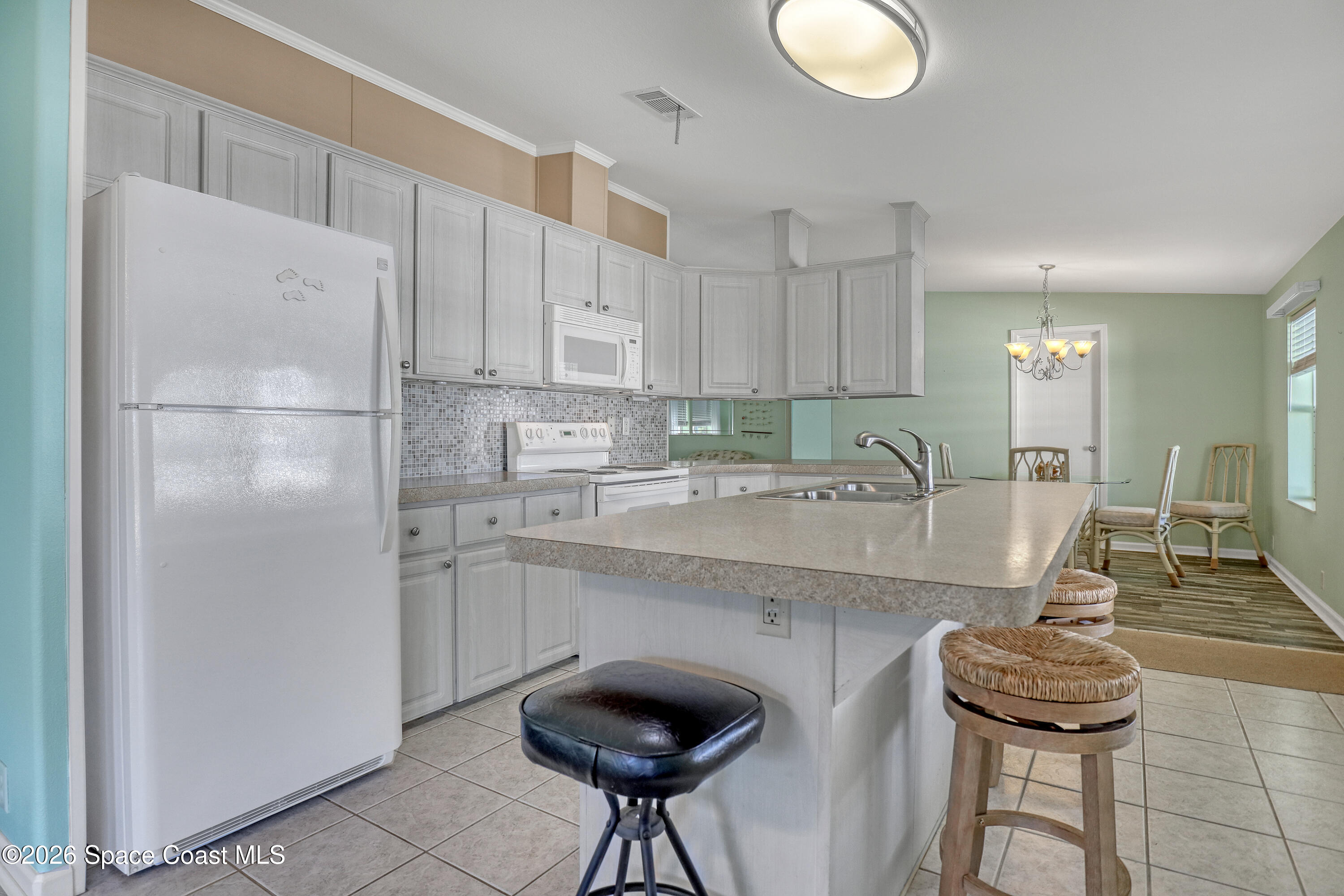 7547 Boxelder Road Micco, FL 32976 - Photo 15 of 53 a kitchen with stainless steel appliances granite countertop a sink and a refrigerator