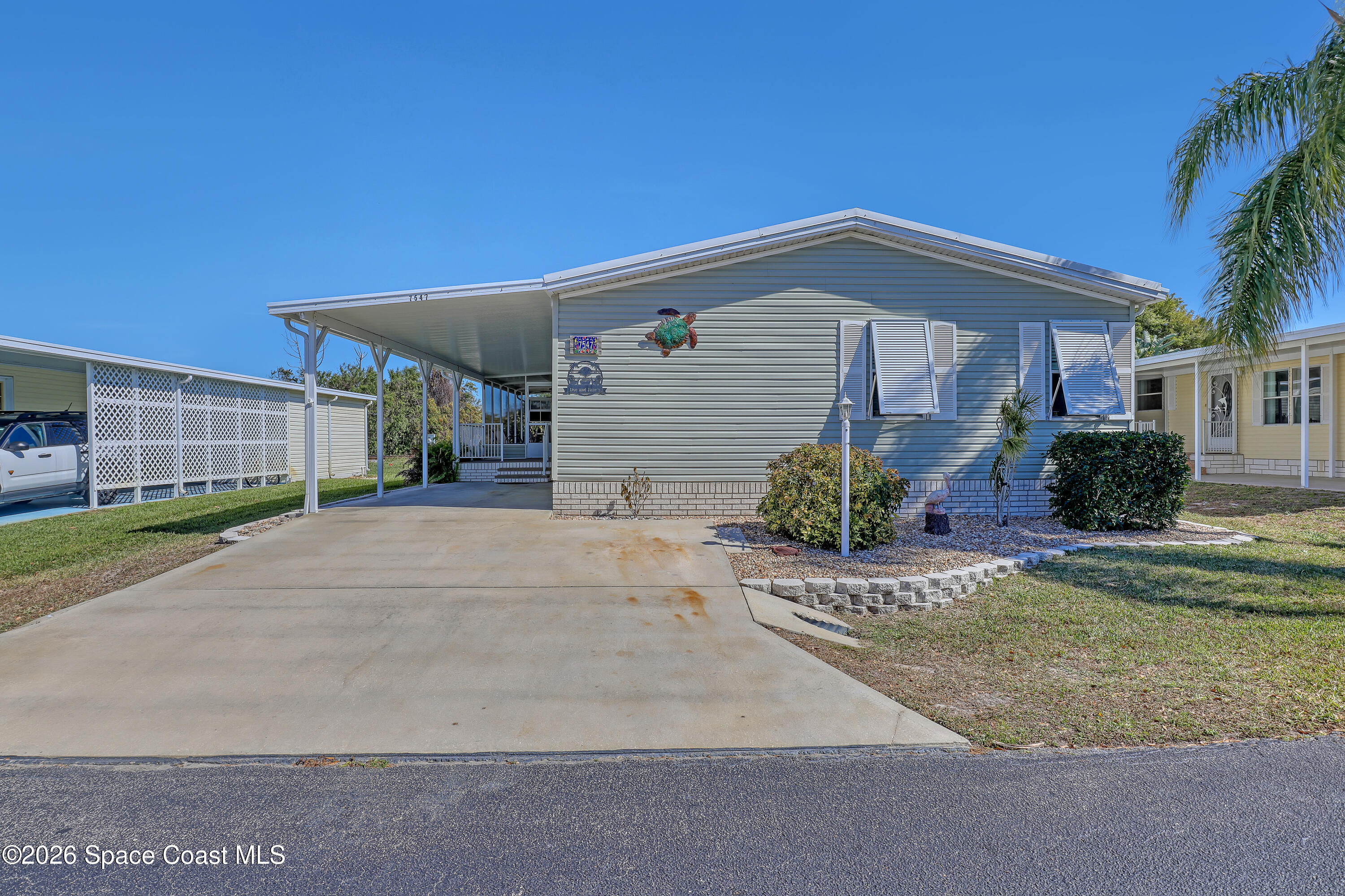 7547 Boxelder Road Micco, FL 32976 - Photo 2 of 53 a front view of a house with a yard and garage