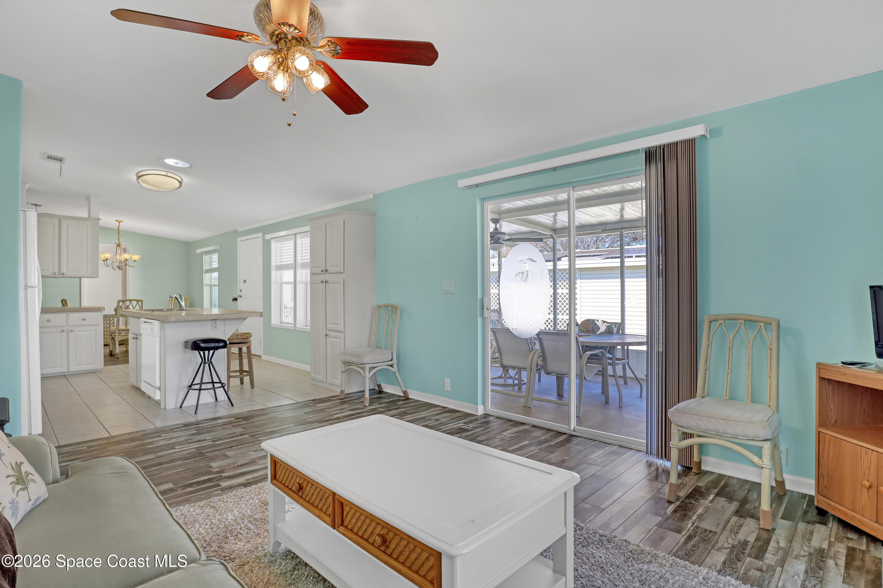 7547 Boxelder Road Micco, FL 32976 - Photo 21 of 53 a living room with furniture a table and kitchen view