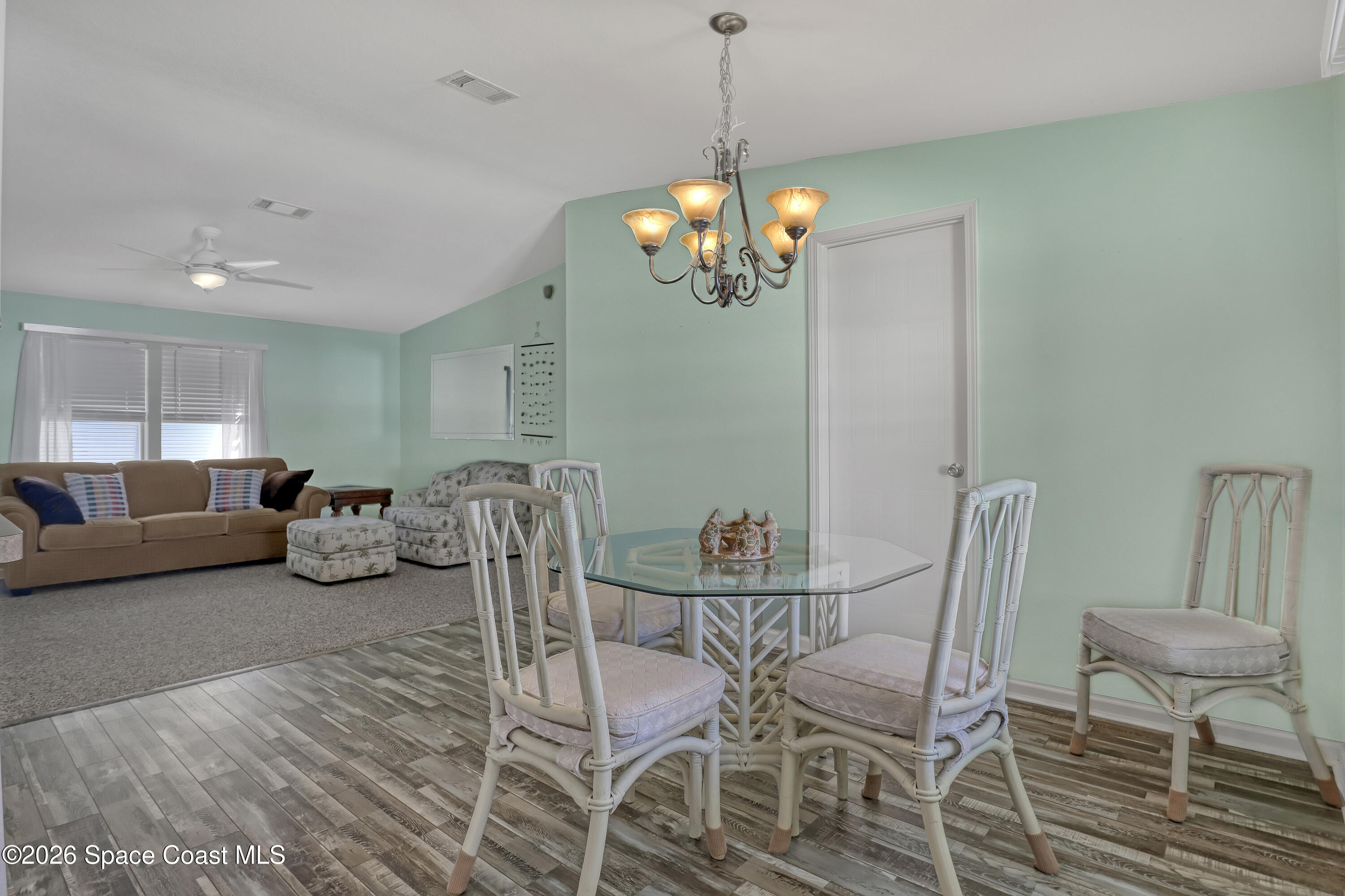 7547 Boxelder Road Micco, FL 32976 - Photo 8 of 53 a view of a dining room with furniture a chandelier and wooden floor