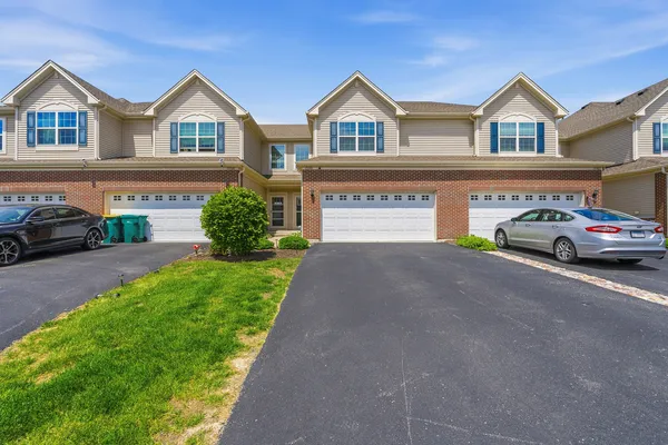 a front view of a house with a garden and parking