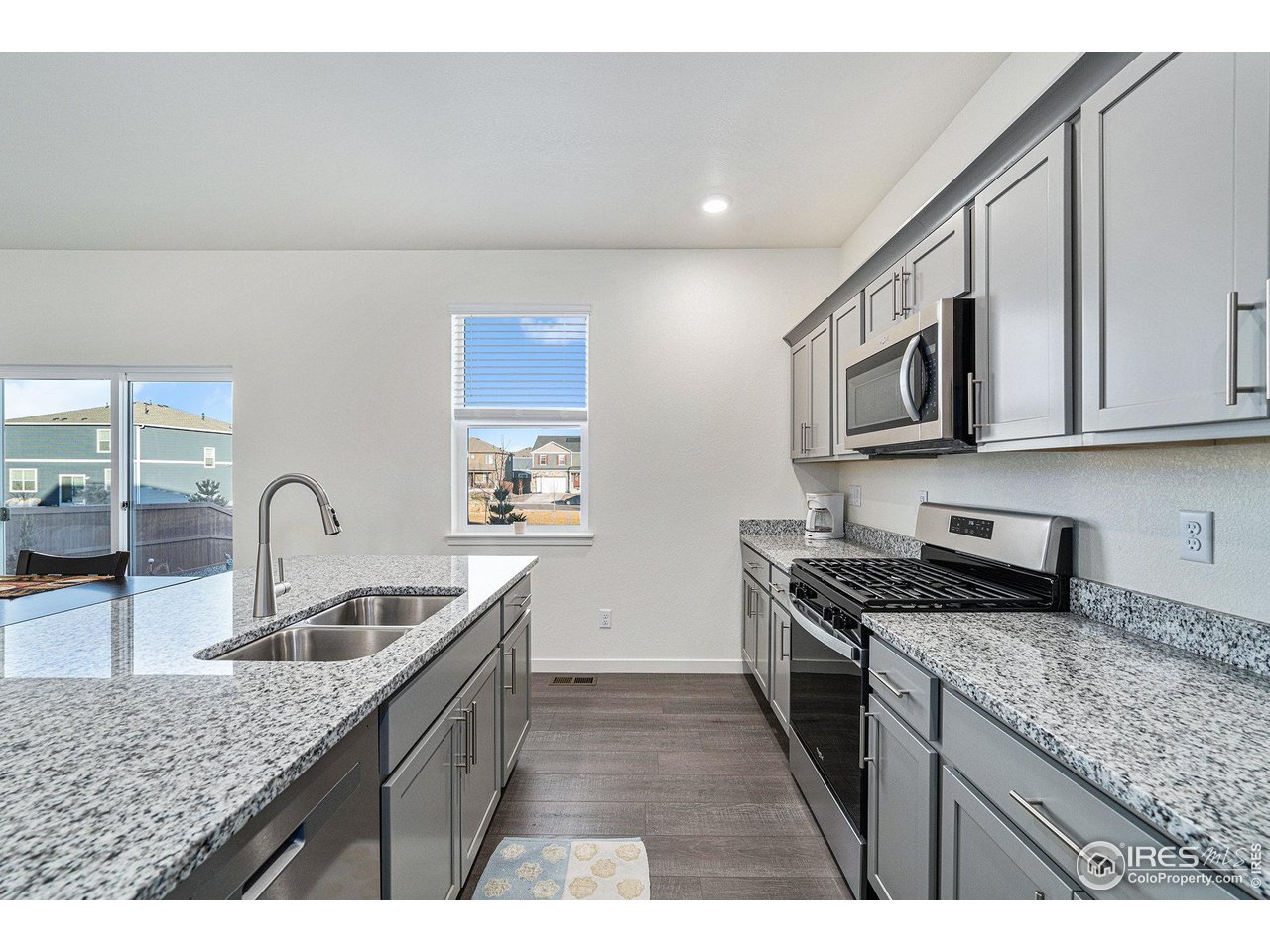 a kitchen with granite countertop stainless steel appliances sink stove microwave and cabinets