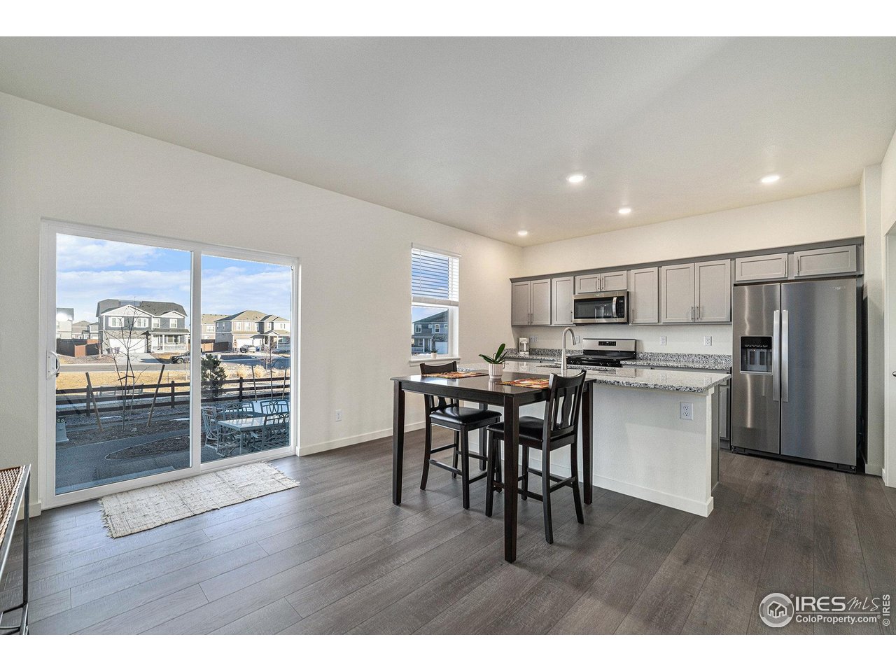 439 Bluebird Road Johnstown, CO 80534 - Photo 13 of 37 a kitchen with stainless steel appliances wooden floor and large window