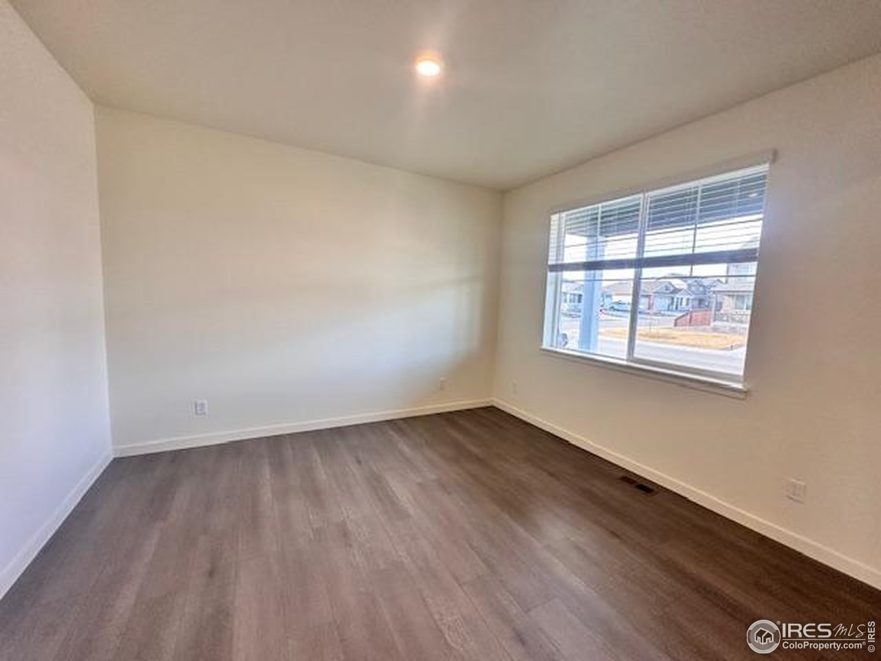 439 Bluebird Road Johnstown, CO 80534 - Photo 9 of 37 an empty room with wooden floor and windows