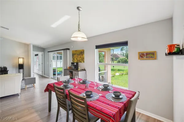 a kitchen with stainless steel appliances granite countertop a sink a stove a refrigerator cabinets and chairs