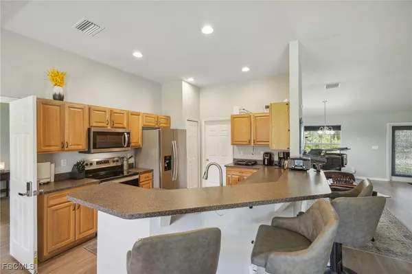 a kitchen with stainless steel appliances granite countertop sink refrigerator and microwave