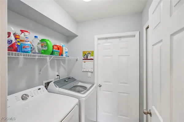 a bedroom with a bed a chandelier and a flat tv