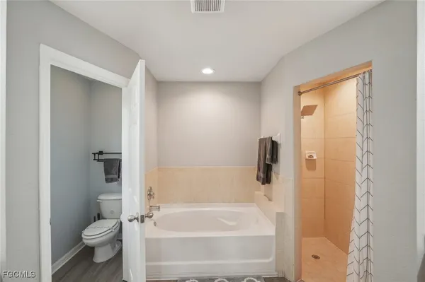 a bedroom with a bed and a flat tv screen on a table