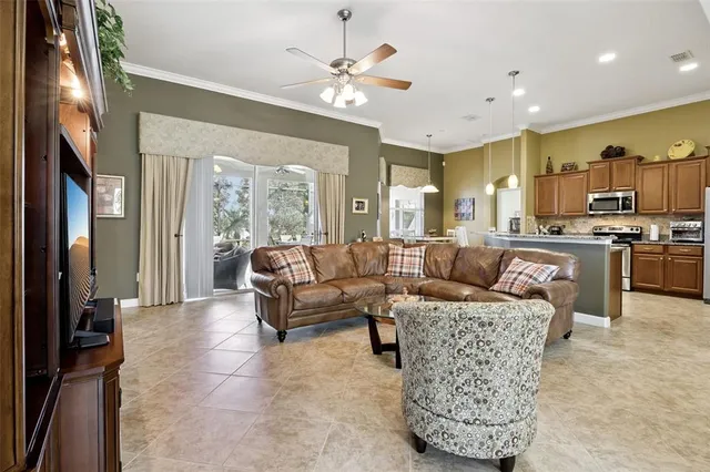 a living room with furniture a large window and a chandelier