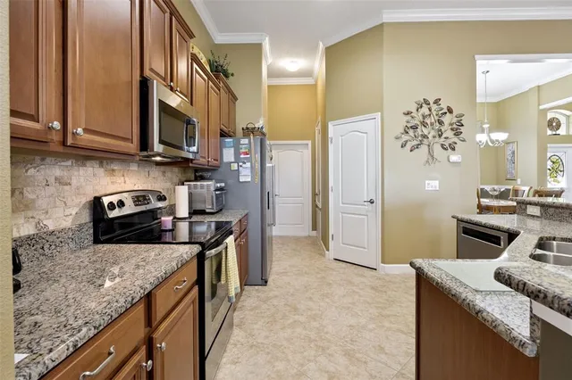 a kitchen with stainless steel appliances granite countertop a sink a stove and a refrigerator