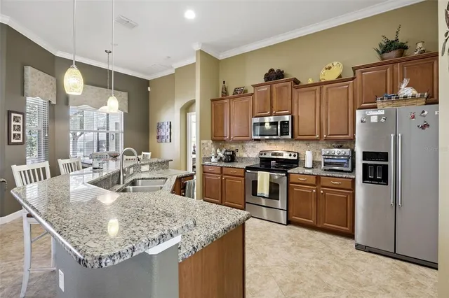 a kitchen with stainless steel appliances granite countertop a sink refrigerator and cabinets
