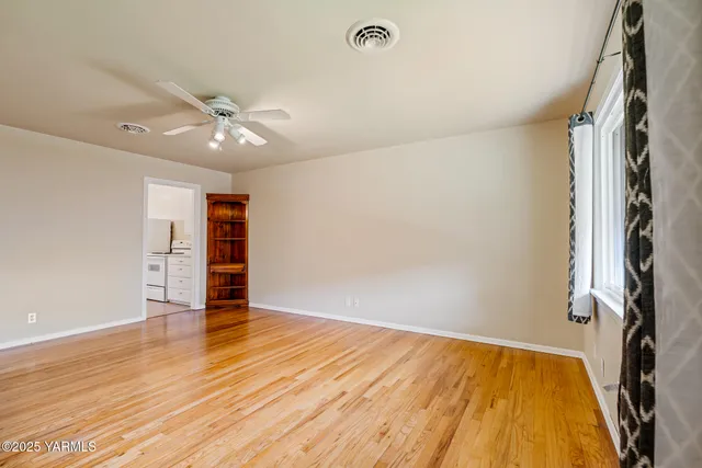 wooden floor in an empty room with a window