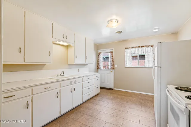 a room with white cabinets and sink