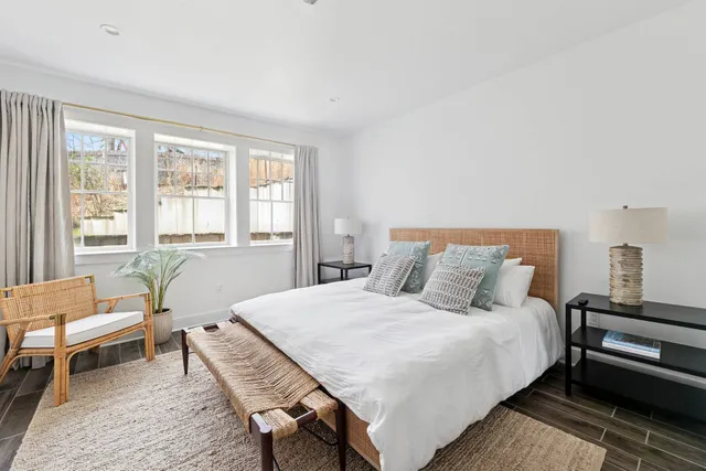 a bedroom with a bed wooden floor and lamp