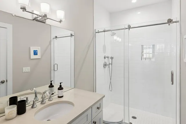a bathroom with a sink toilet double vanity and shower