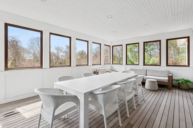 a view of a dining room with furniture large windows and wooden floor