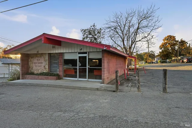 a front view of a building with streets and trees