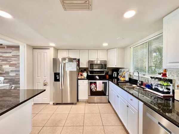 a kitchen with stainless steel appliances a refrigerator sink and microwave