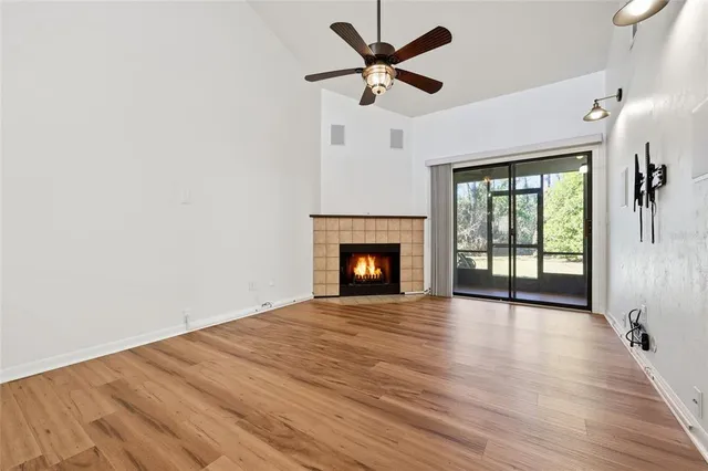 a view of an empty room with wooden floor and a fireplace
