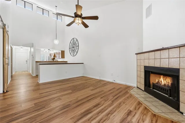 a view of a room with wooden floor fireplace and windows