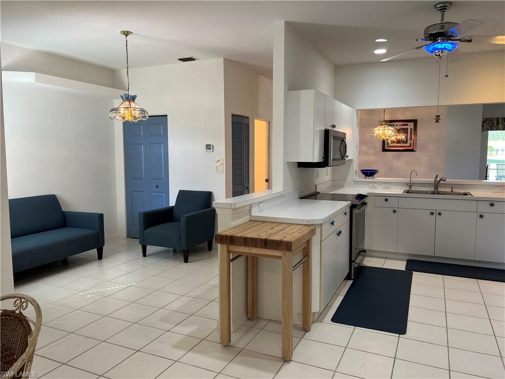 2081 Crestview Way, Unit A7 Naples, FL 34119 - Photo 15 of 33 a kitchen that has a sink a counter top space appliances and cabinets