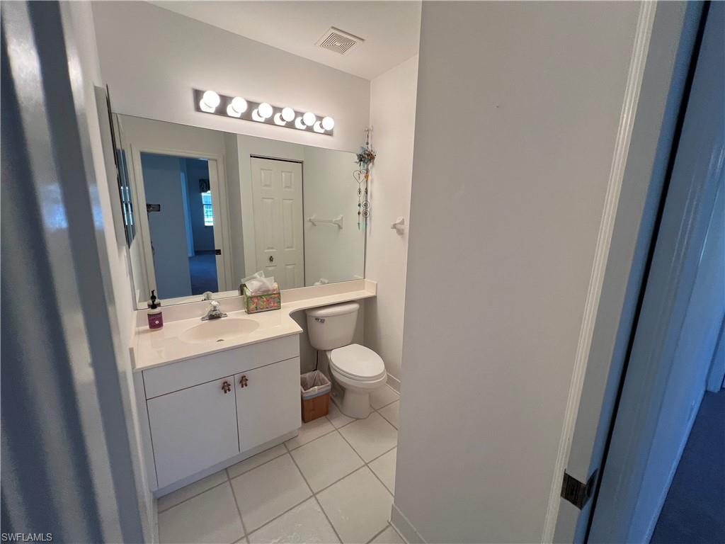 2081 Crestview Way, Unit A7 Naples, FL 34119 - Photo 18 of 33 a bathroom with a toilet a sink and mirror