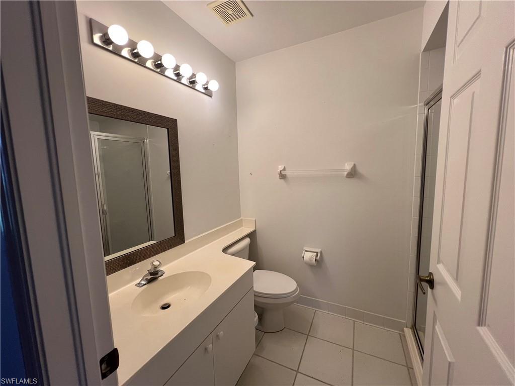 2081 Crestview Way, Unit A7 Naples, FL 34119 - Photo 21 of 33 a bathroom with a toilet a sink a mirror a vanity and shower