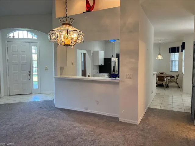 a view of an empty room with a chandelier fan