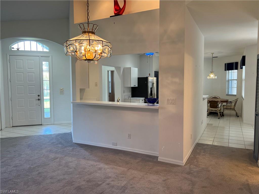 2081 Crestview Way, Unit A7 Naples, FL 34119 - Photo 23 of 33 wooden floor in a room with a chandelier