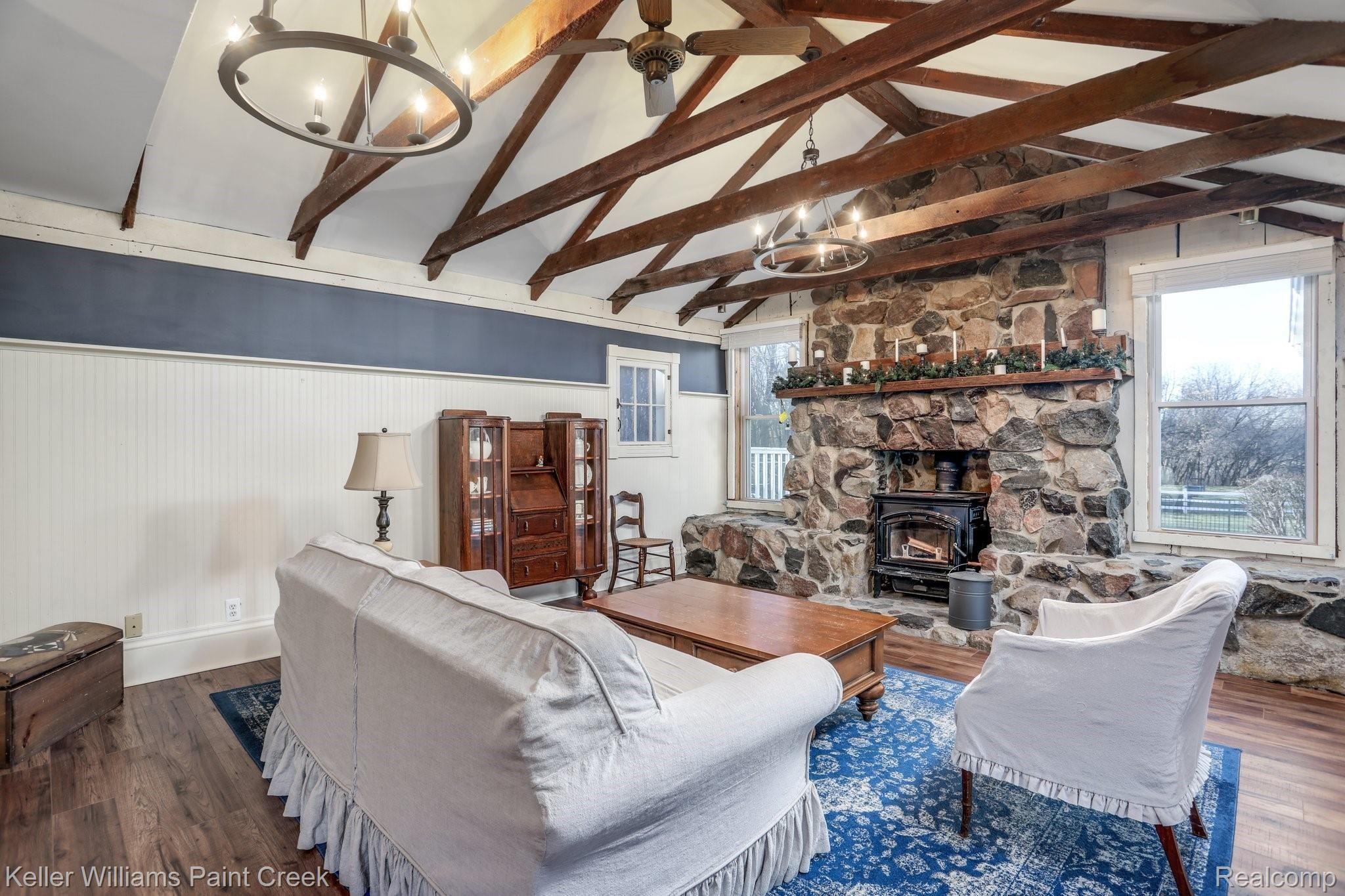 115 Michael Road Lapeer, MI 48446 - Photo 6 of 64 Cathedral Ceilings, Wood Beams, and double 6-Candle Light Wagon Wheel Chandeliers provide a rustic cozy feel in the main Family Room