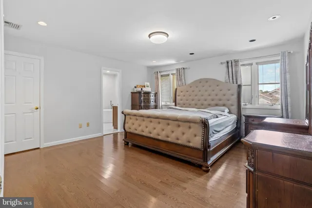 a bedroom with a bed lamp and a large window