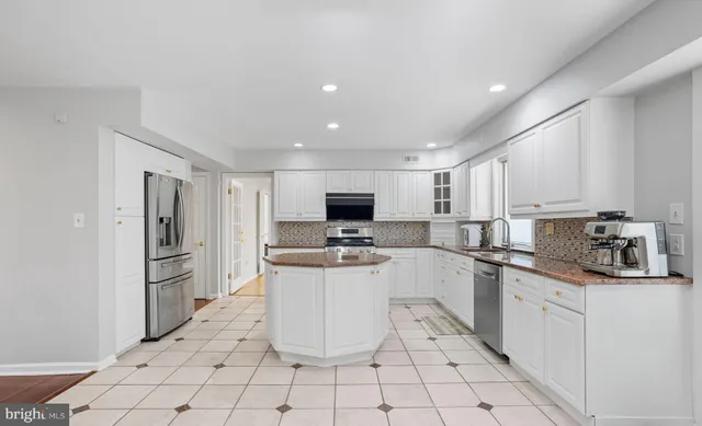 a kitchen with white cabinets a sink and appliances