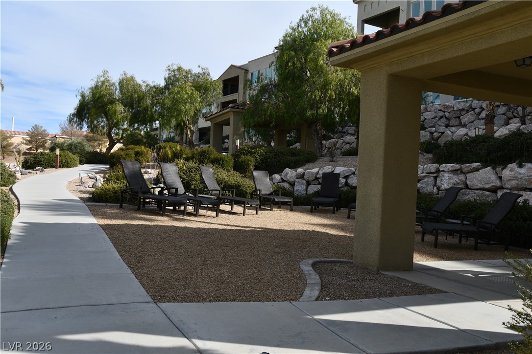 2555 Hampton Road, Unit 7109 Henderson, NV 89052 - Photo 5 of 34 A graceful curved walkway winds through well-maintained landscaping, creating an inviting outdoor retreat.
