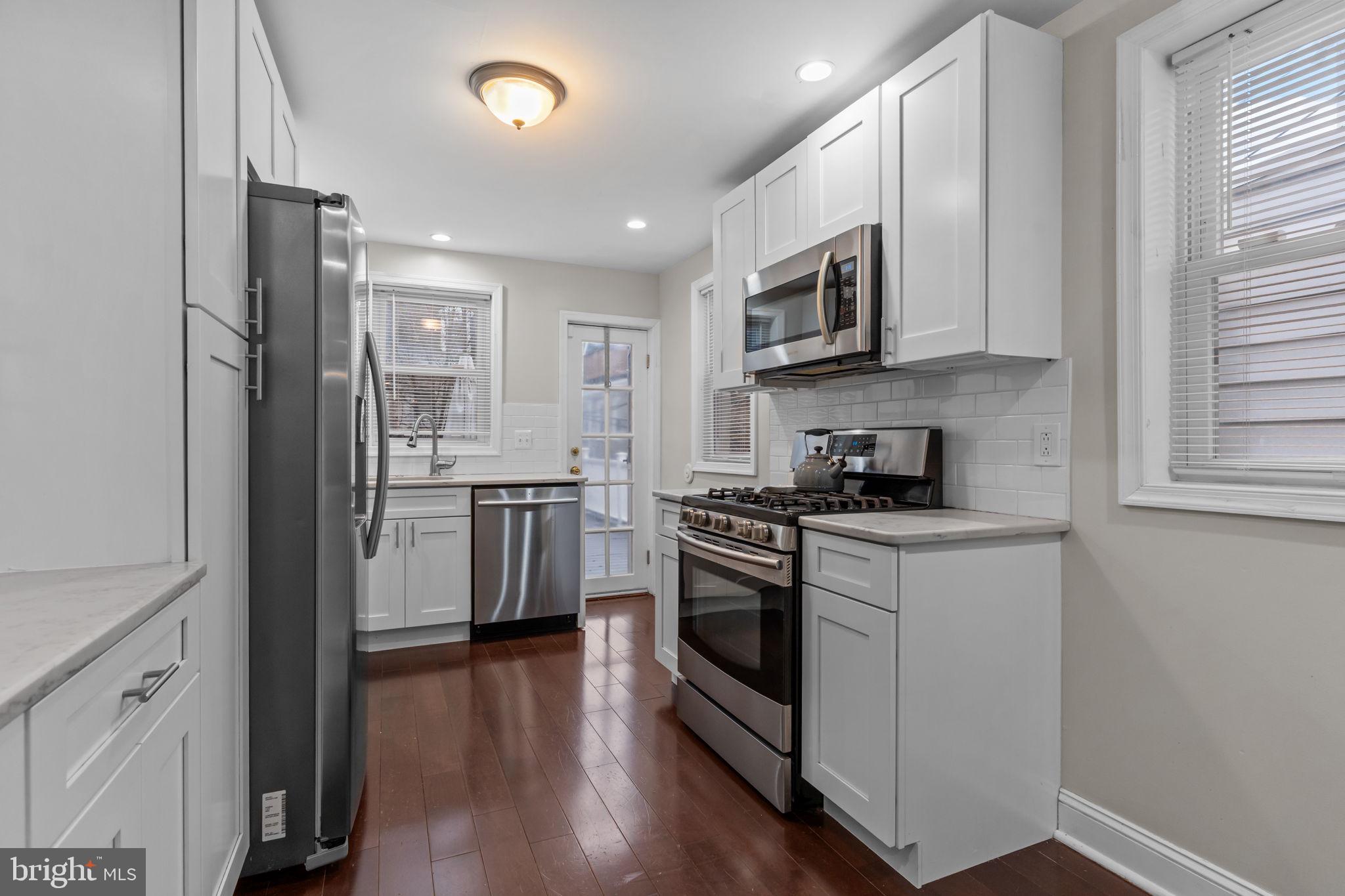 3554 New Queen Street Philadelphia, PA 19129 - Photo 11 of 39 a kitchen with stainless steel appliances granite countertop a stove a sink and a refrigerator