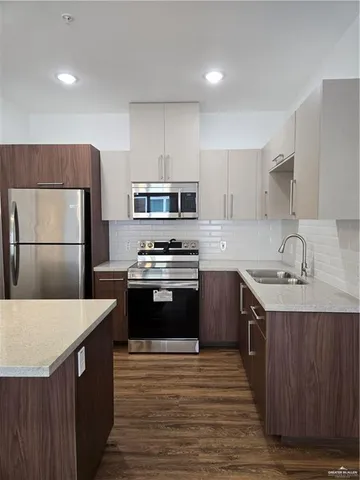 a kitchen with a sink a stove a refrigerator and cabinets