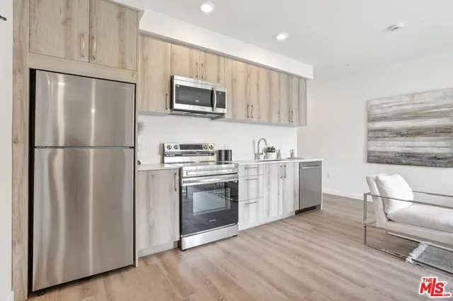 a kitchen with stainless steel appliances a refrigerator sink and microwave
