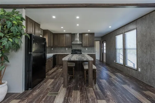 a kitchen with stainless steel appliances granite countertop a table chairs sink and cabinets
