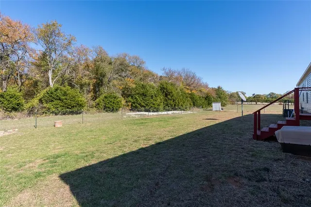 a view of a field with trees in background