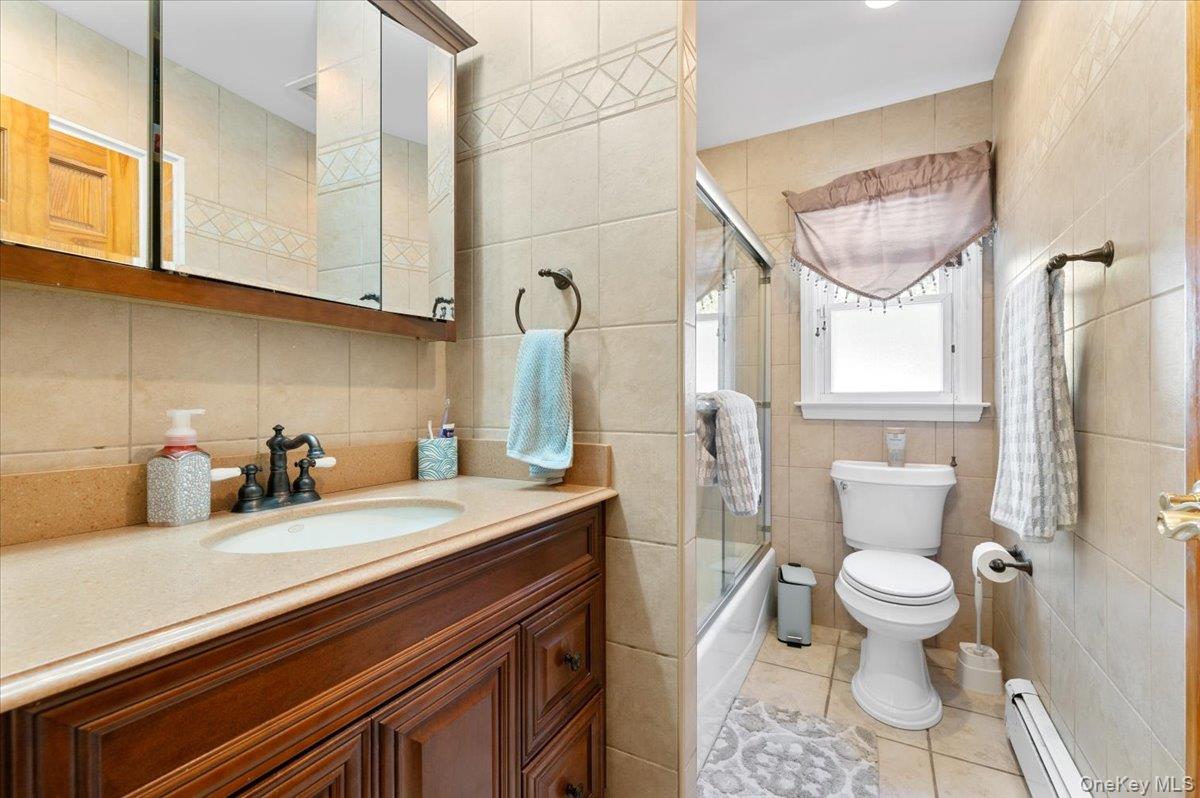 21 Eleanor Road Plainview, NY 11803 - Photo 14 of 39 a bathroom with a sink a toilet and a mirror