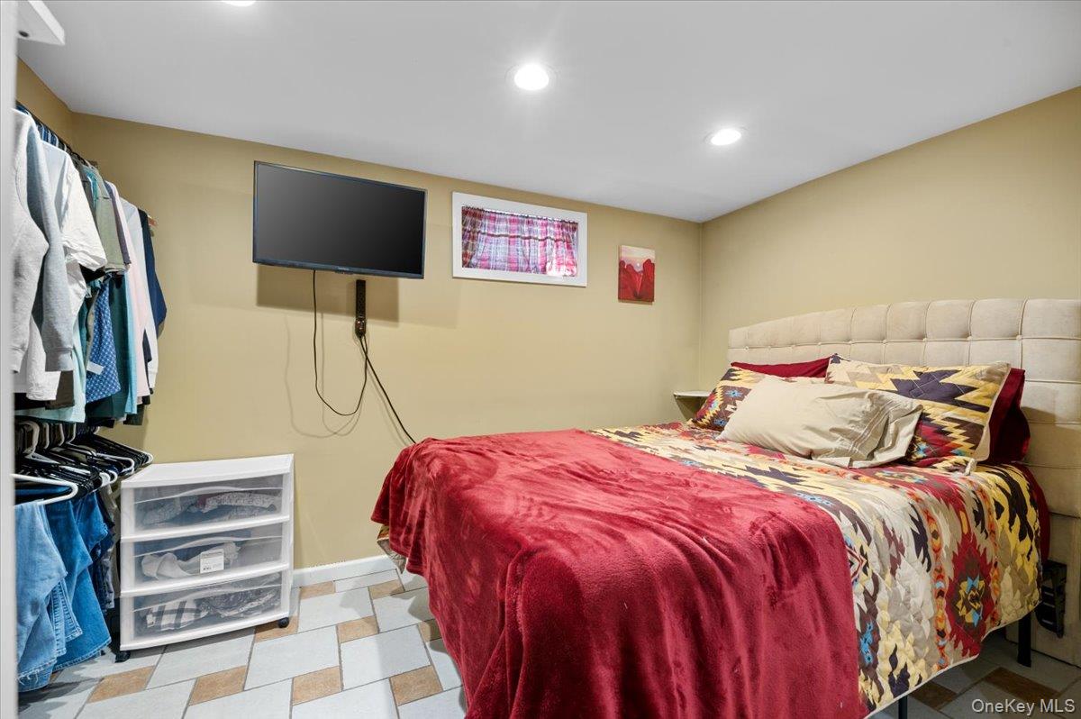 21 Eleanor Road Plainview, NY 11803 - Photo 25 of 39 a bed room with a bed and a flat screen tv
