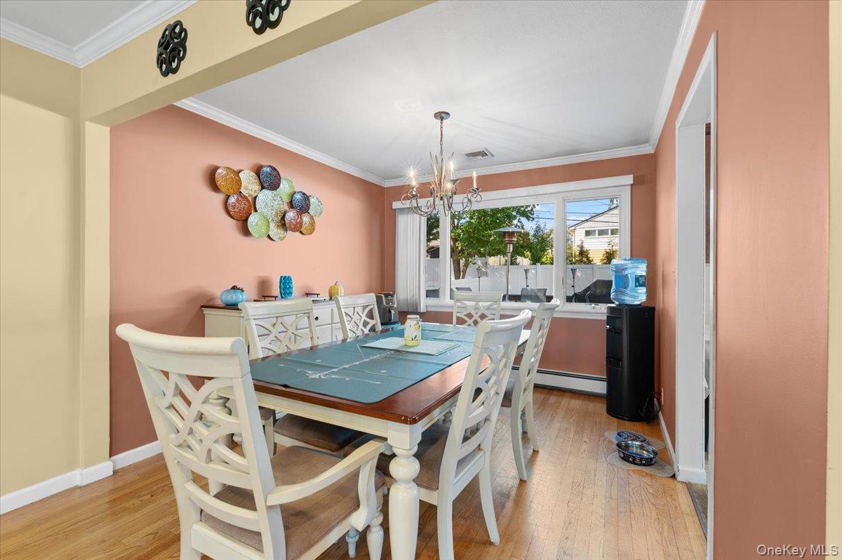 21 Eleanor Road Plainview, NY 11803 - Photo 7 of 39 a view of a dining room with furniture and a chandelier