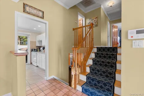 a view of a hallway to a livingroom with wooden floor and entryway