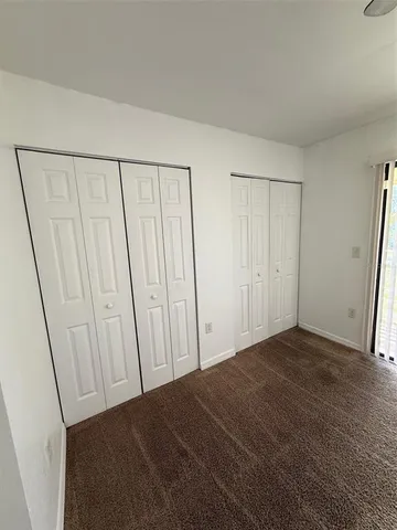 a view of a swimming pool with a table and chairs under an umbrella